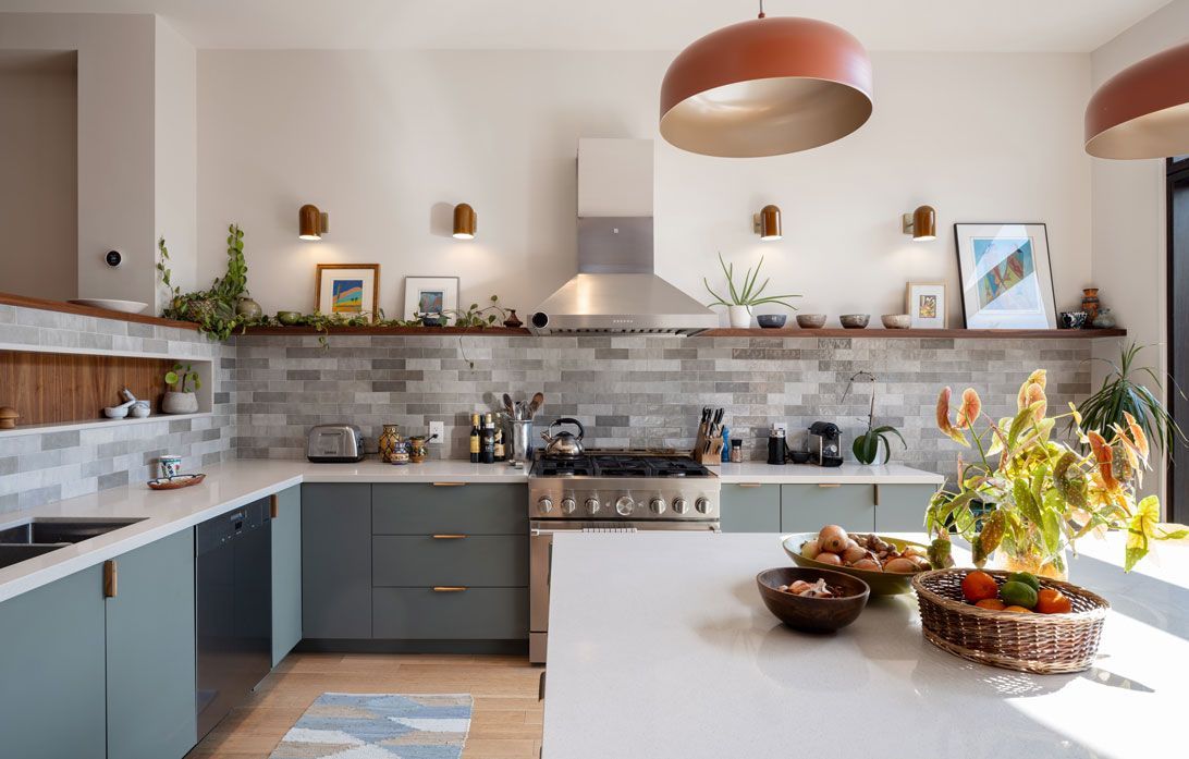 A kitchen addition with blue cabinets , white counter tops , a stove , and a large island.