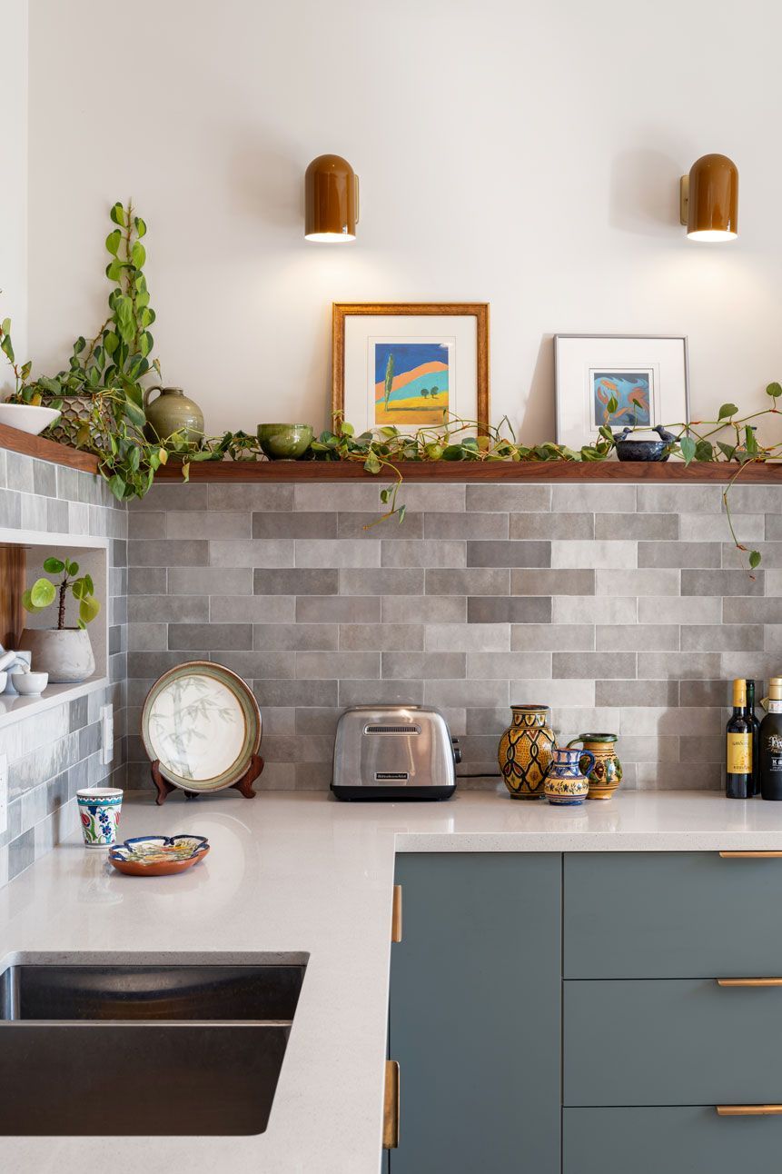 A kitchen addition with a sink , toaster oven , and a shelf above the sink.