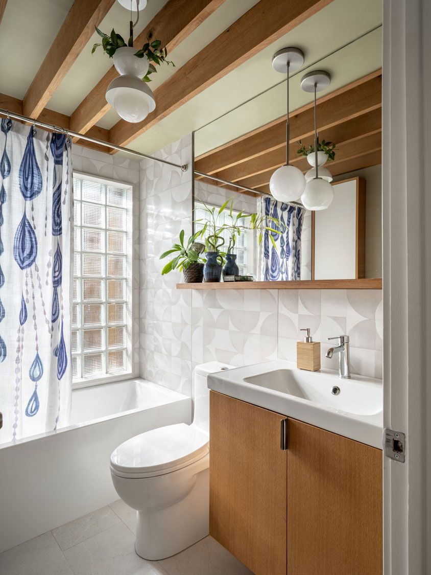 A bathroom addition with a toilet , sink , tub and mirror.