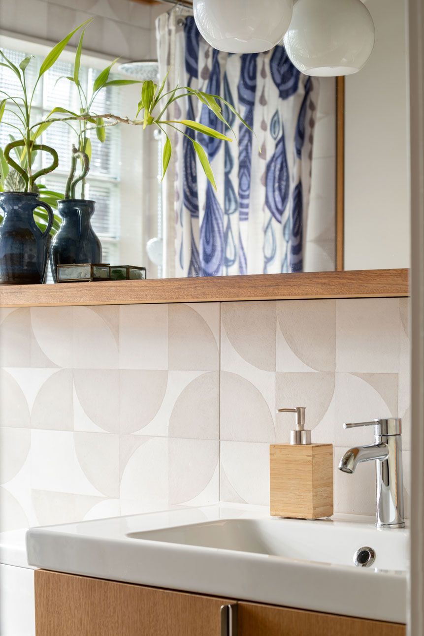 A bathroom addition with a sink , mirror and a window.
