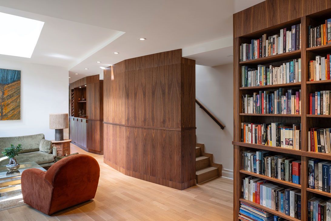 A living room with lots of built-in bookshelves and stairs
