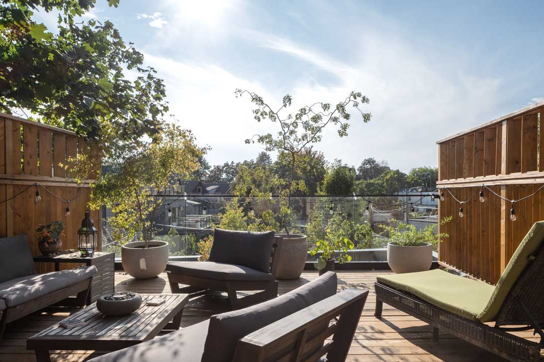 A patio with a lot of furniture and a wooden fence