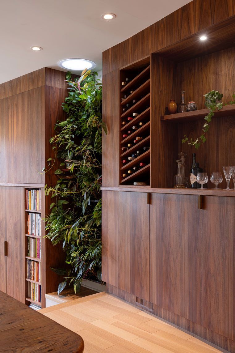 A home addition with built-in wooden cabinets and a wine rack.