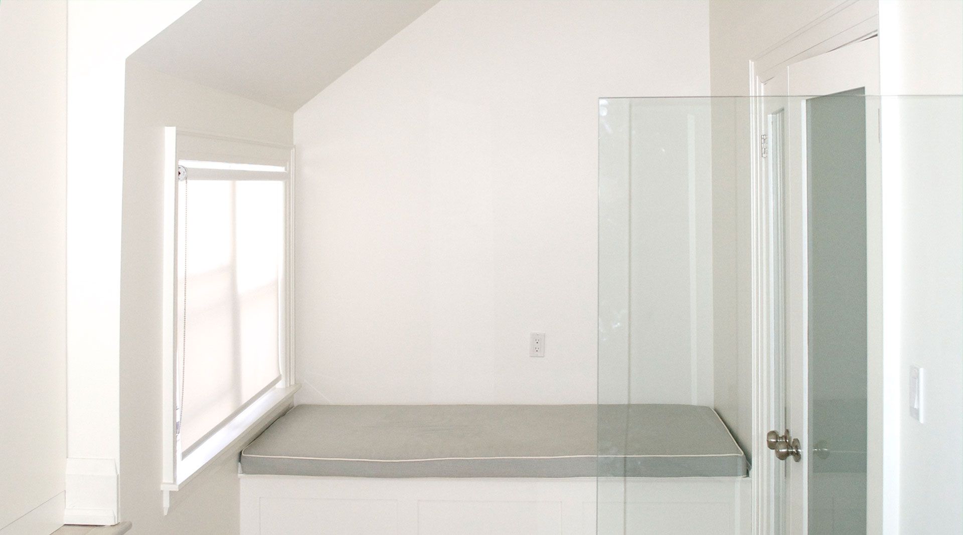 A bathroom with a walk in shower and a window.