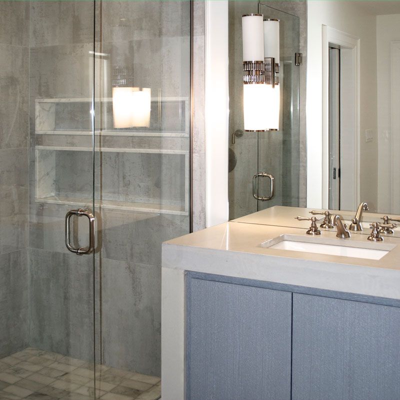 A bathroom with a sink a mirror and a walk in shower