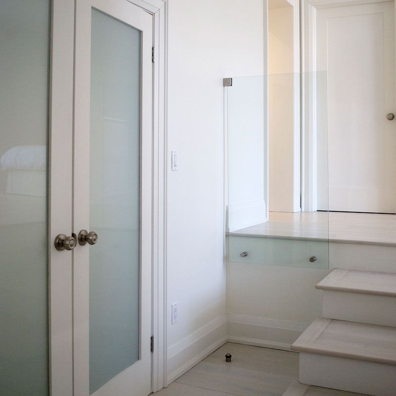 A hallway with a glass door and stairs