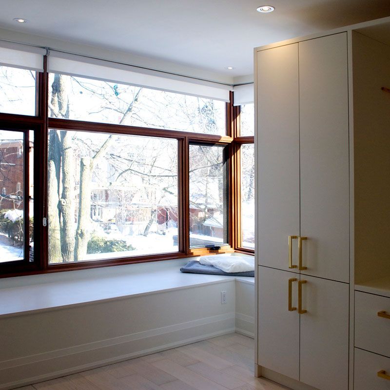 A room with a large window and white cabinets