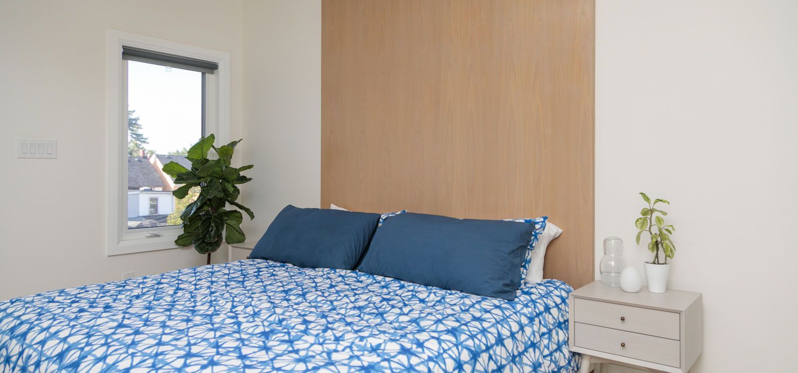 A bedroom with a bed , nightstand , and window.