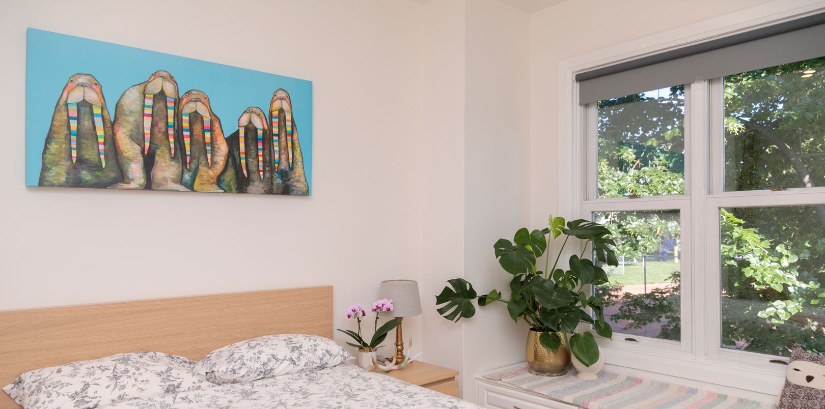 There is a painting on the wall above the bed in the bedroom.
