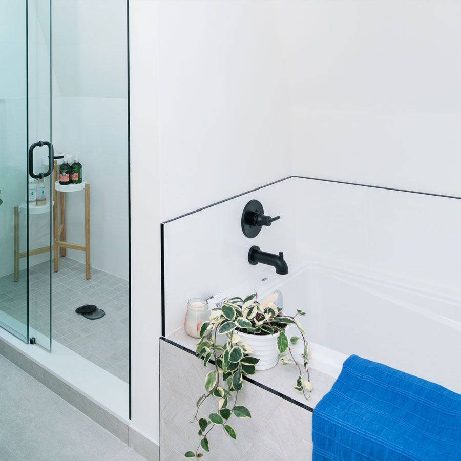 A bathroom with a blue towel on the edge of the tub