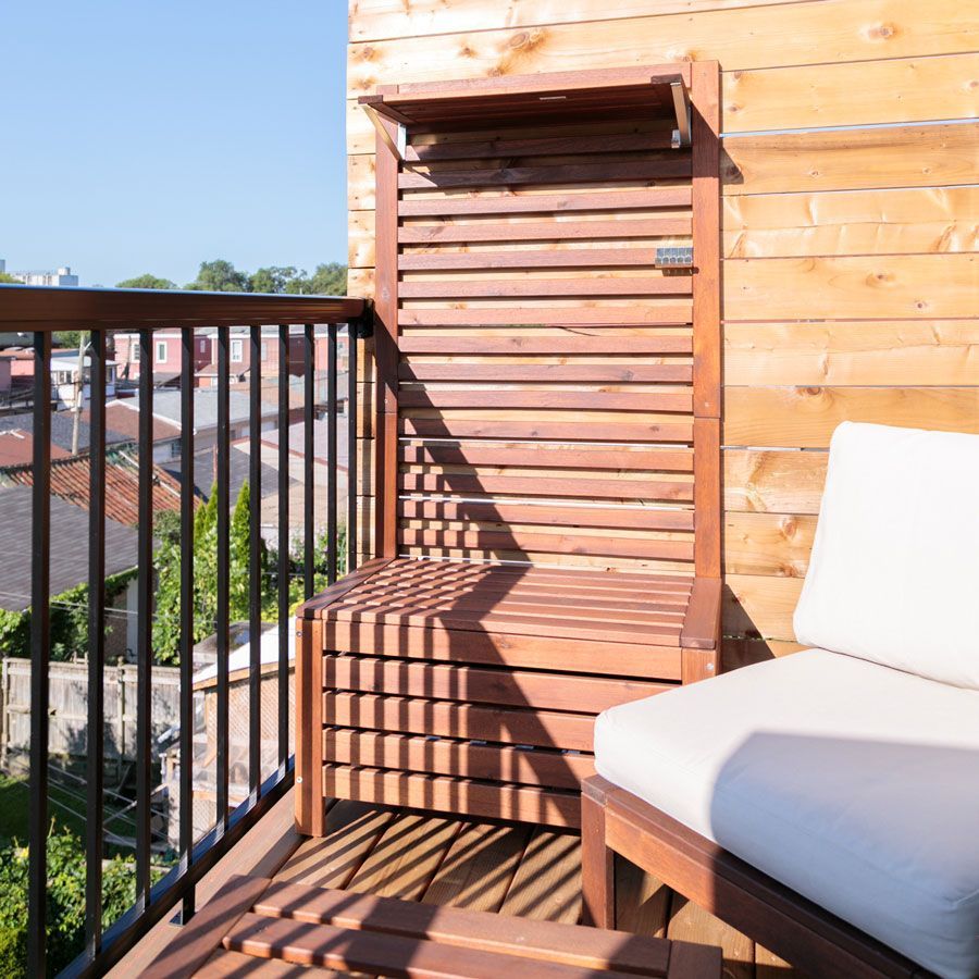 A balcony with a wooden bench and chair