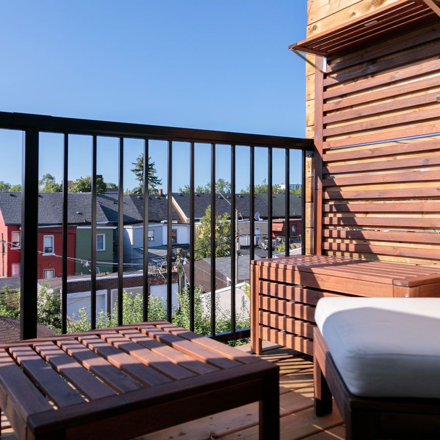 A balcony with a chair and a table with a view of a city