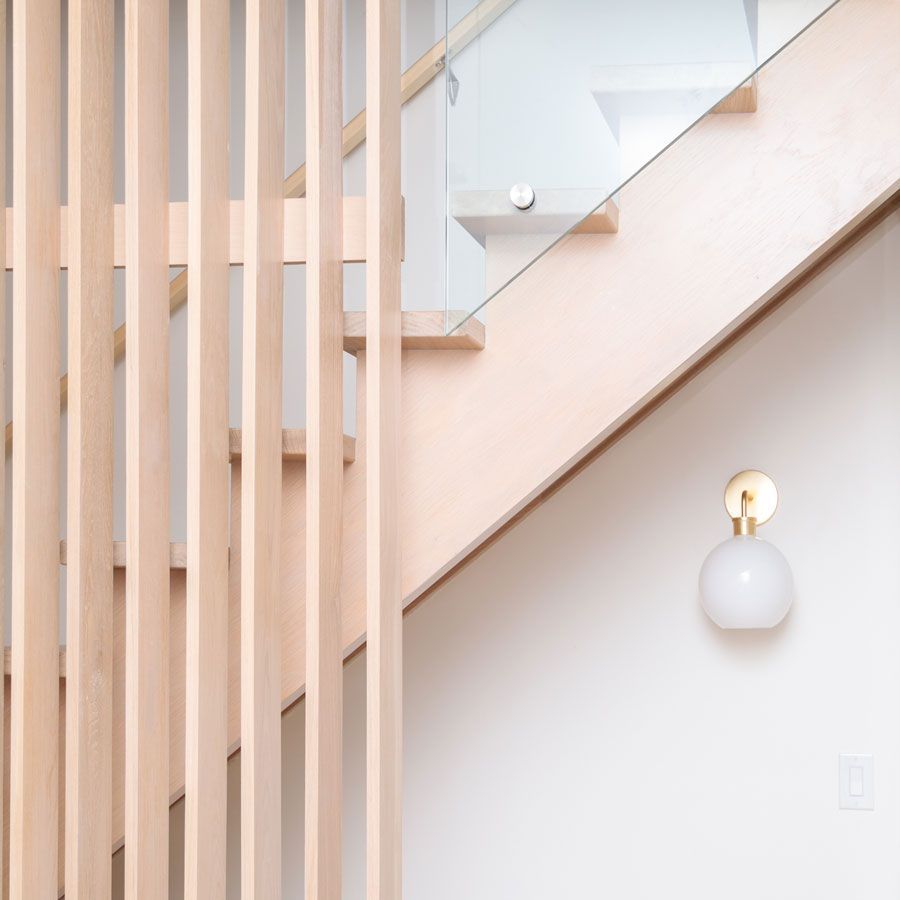 A staircase with a wooden railing and a glass railing