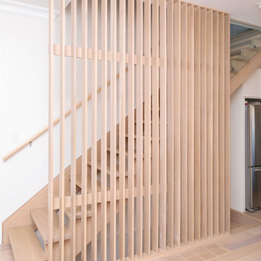 A wooden staircase with a wooden railing in a house.