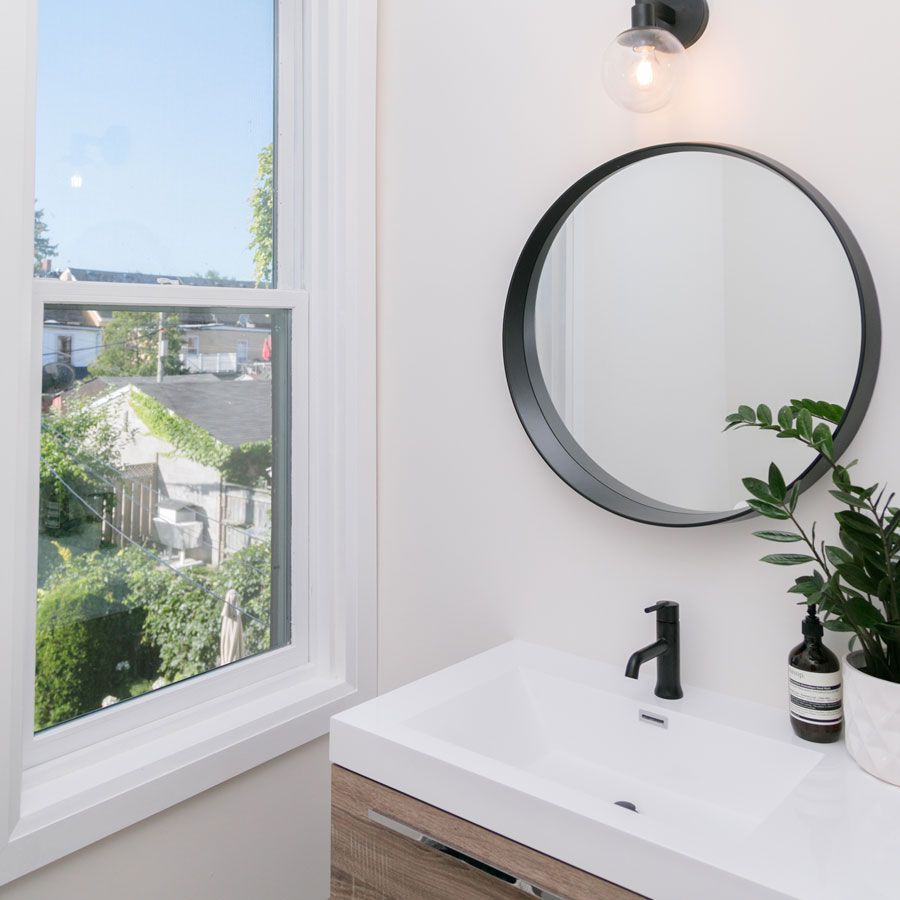 A bathroom with a sink a mirror and a window