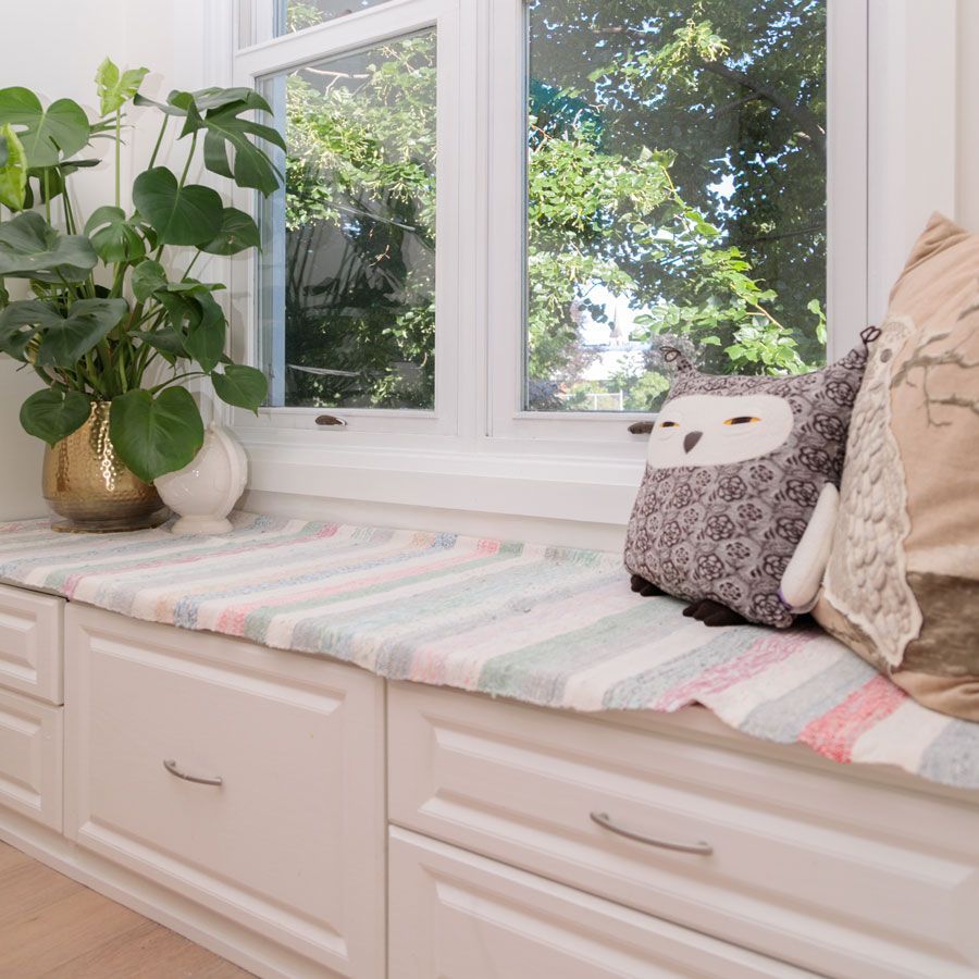 A window seat with pillows and a stuffed owl on it