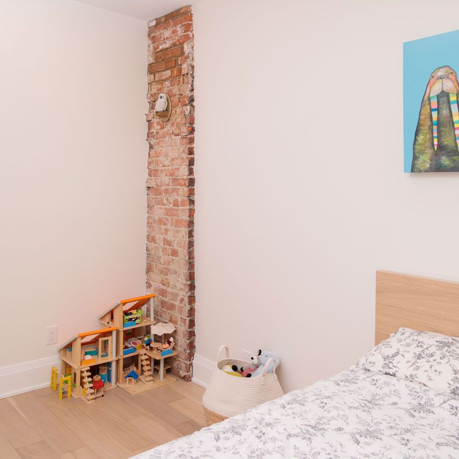 A bedroom with a bed a doll house and a painting on the wall