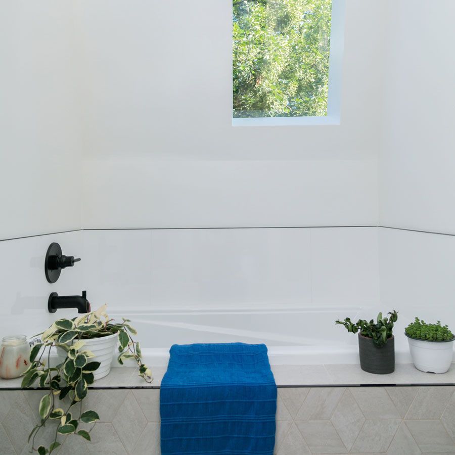 A bathroom with a blue towel on the edge of the tub