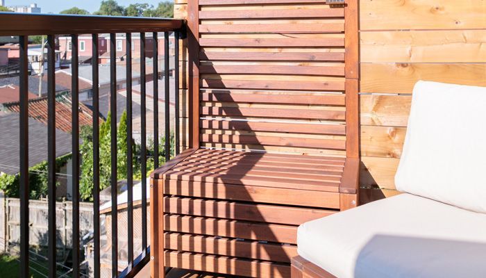 A patio with wicker chairs and a wooden table