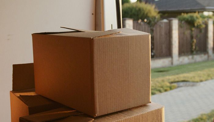 A cardboard box is sitting on top of a stack of cardboard boxes.