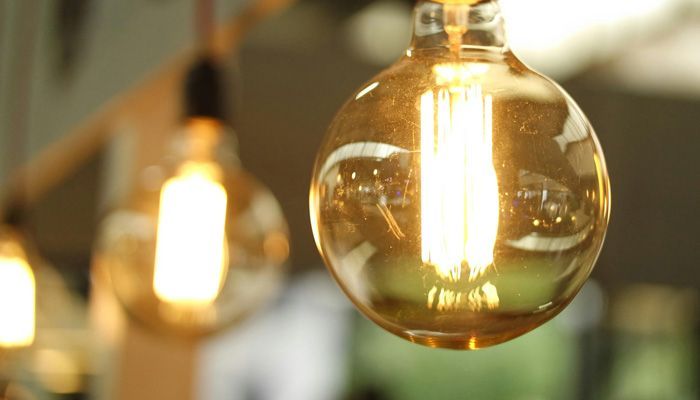 A close up of a light bulb hanging from a ceiling.