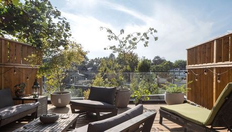 A patio with a couch , chairs , and a table.