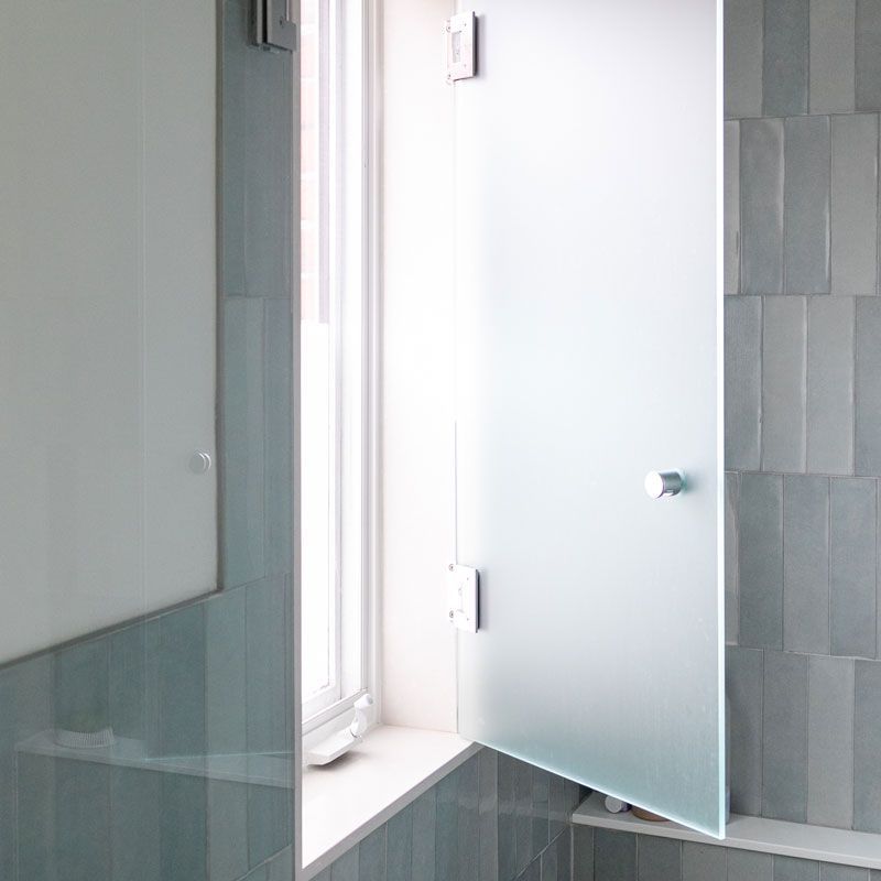 A bathroom with a glass door and a window