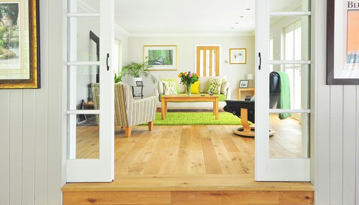 A living room with hardwood floors and sliding glass doors leading to it.