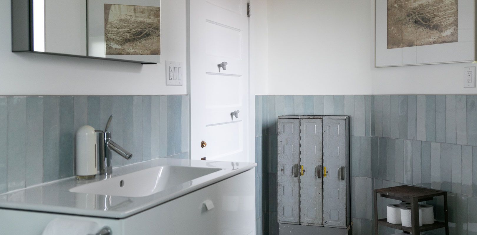 A bathroom with a sink , mirror and cabinet.