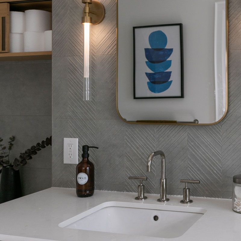 A bathroom with a sink a mirror and a picture on the wall