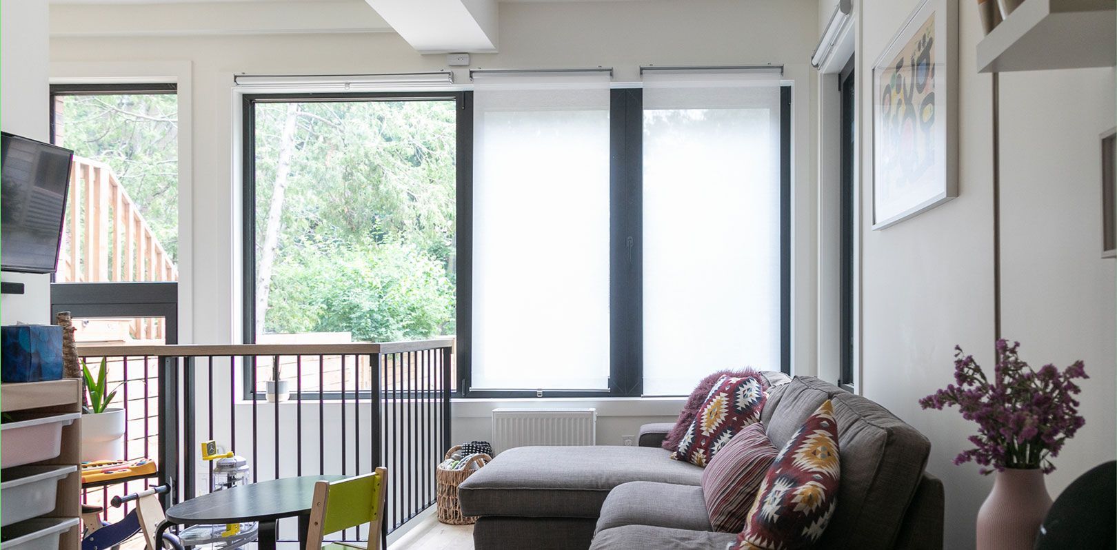A living room with a couch , table , chairs and a balcony.