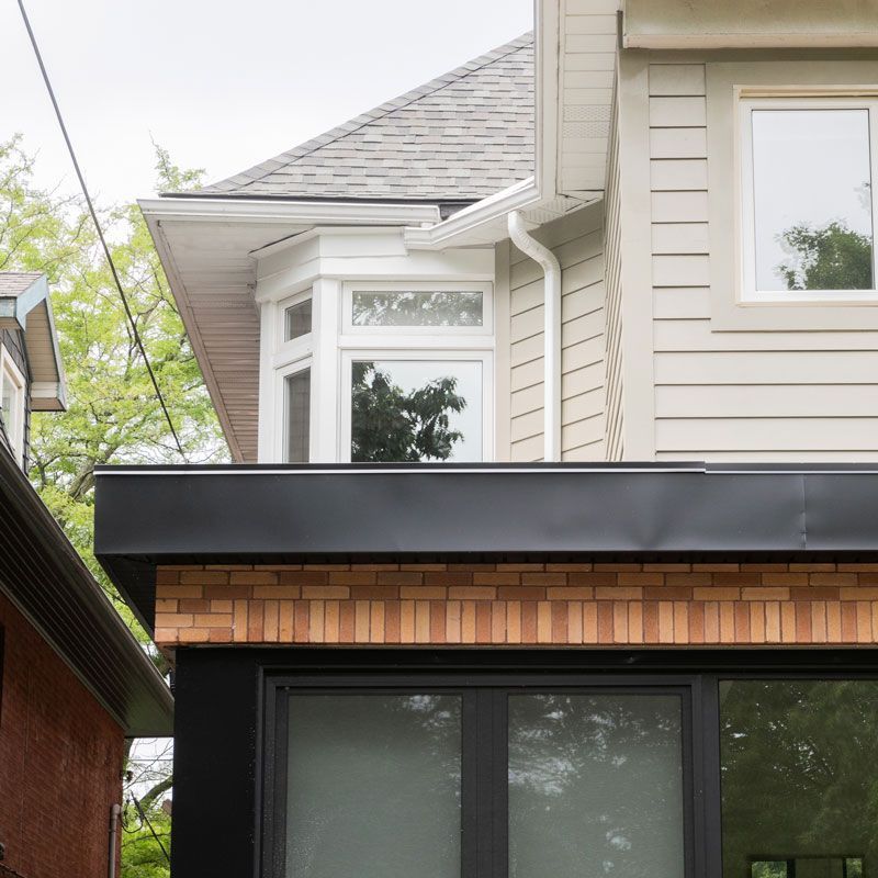 A house with a black roof and a large window