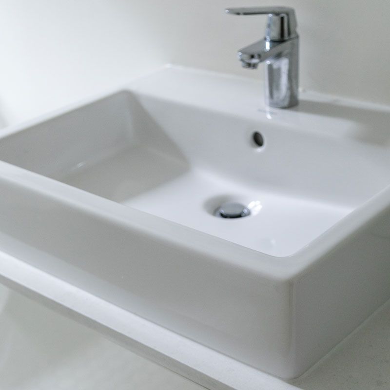 A white bathroom sink with a chrome faucet