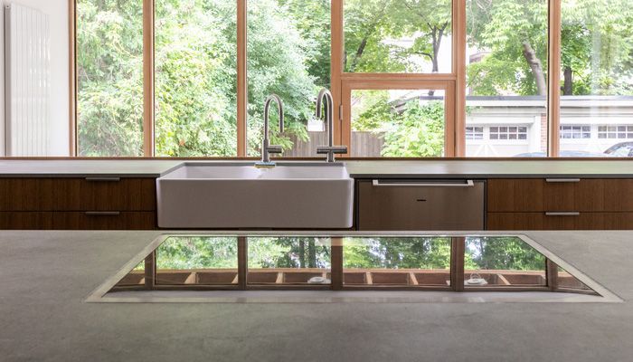 A kitchen with white cabinets , stainless steel appliances , and a large island.