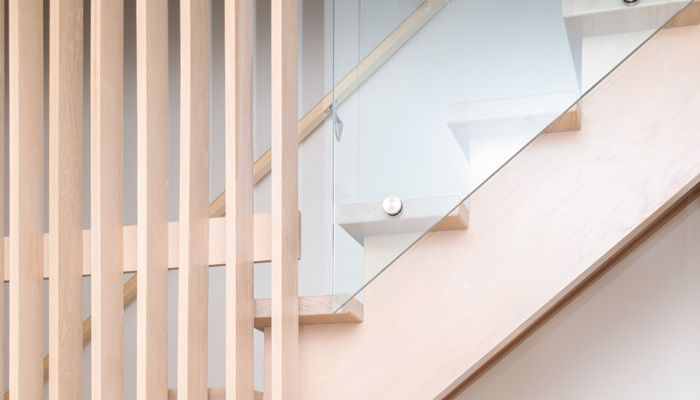 A bedroom with a bed , chairs , and sliding glass doors leading to a balcony.