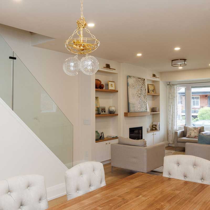 A living room with a wooden table and white chairs