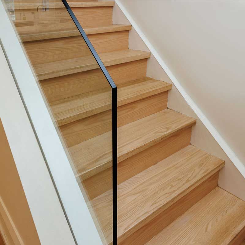 A set of wooden stairs with a glass railing