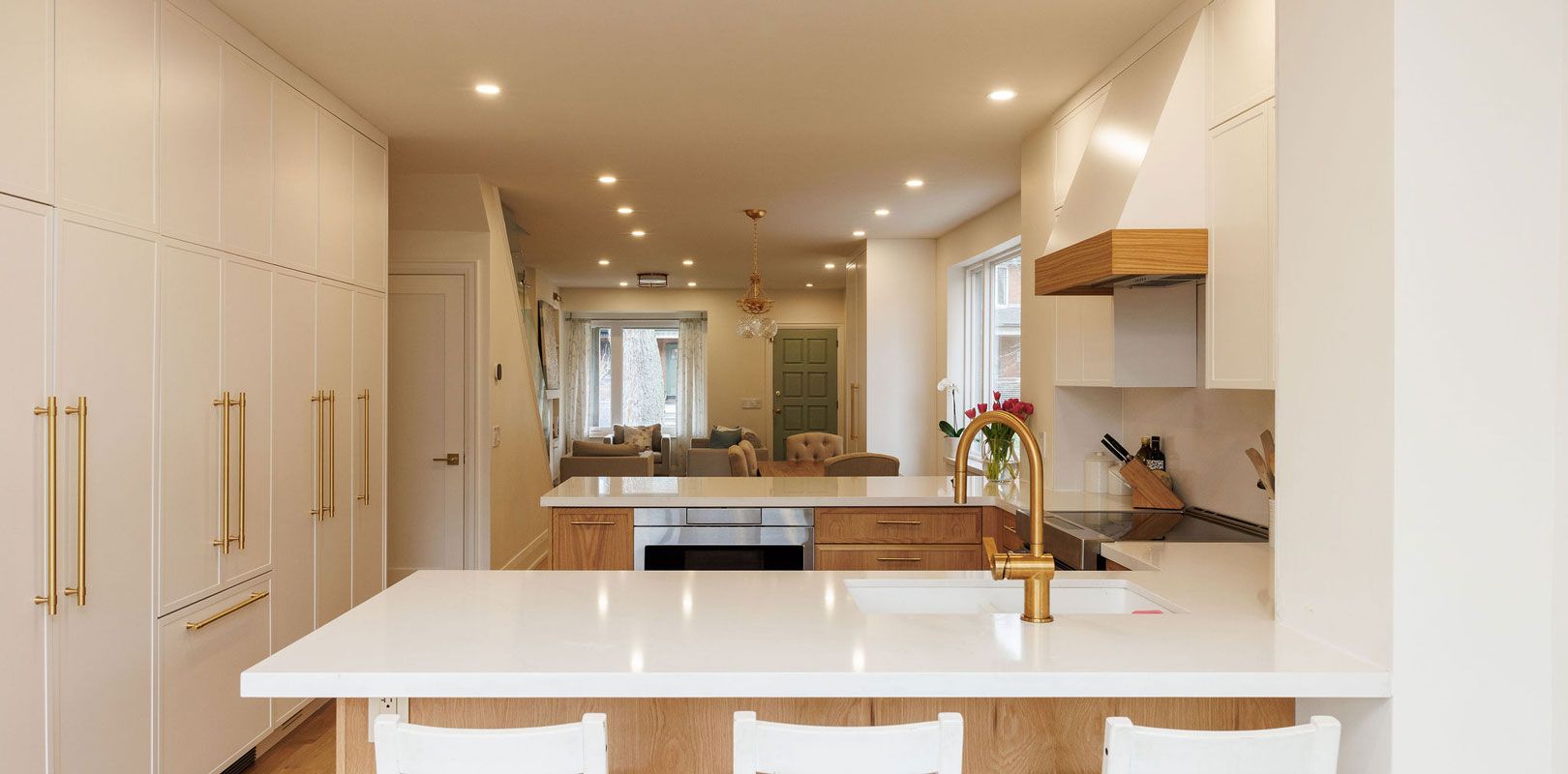 A kitchen with white cabinets , white counter tops , a sink , and a stove.