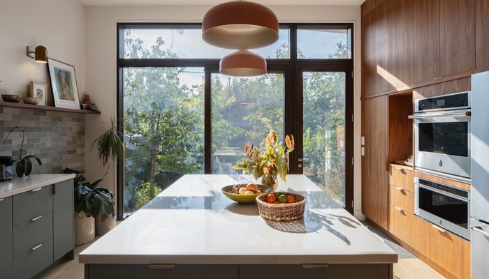 A kitchen with white cabinets , stainless steel appliances , and a large island.