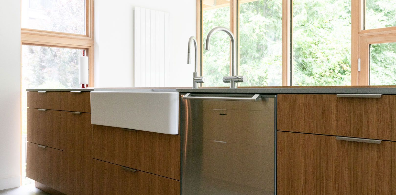 A kitchen with wooden cabinets and a stainless steel dishwasher.