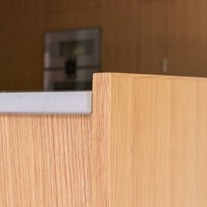 A close up of a wooden cabinet with a counter top in a kitchen.