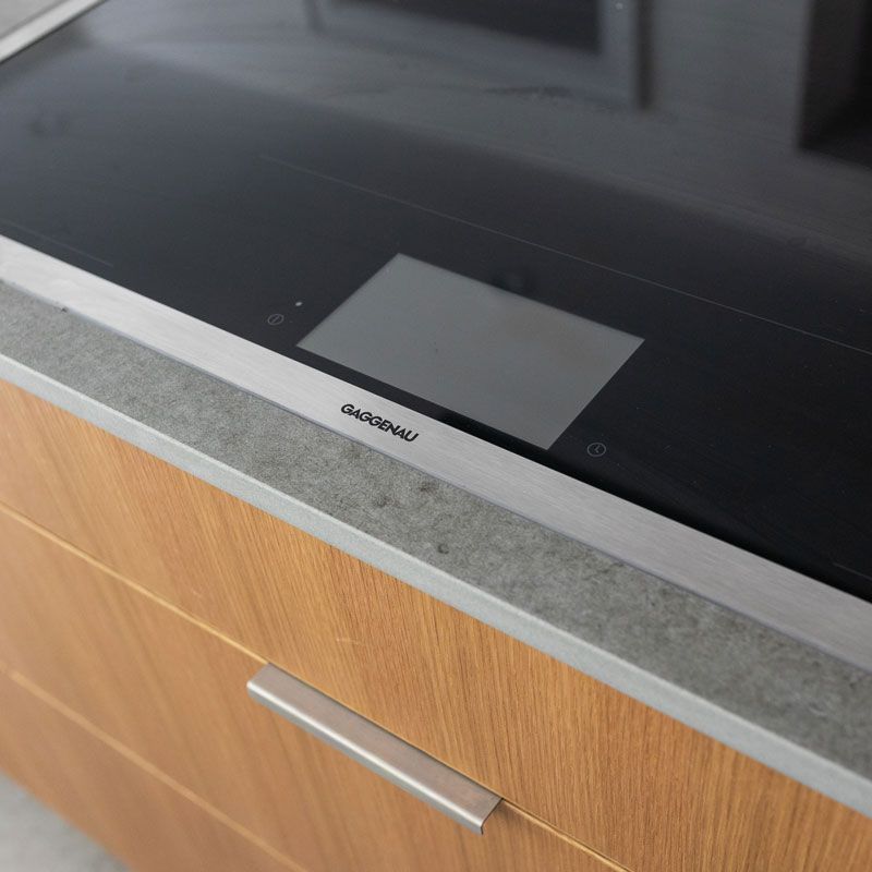 A stainless steel induction stove with a touch screen