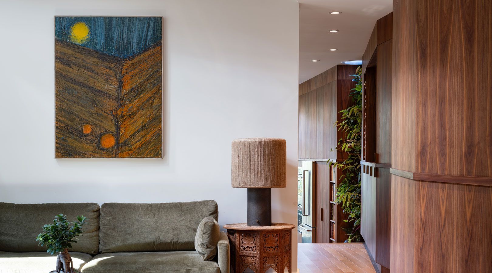 There is a painting on the wall above the couch in the living room.