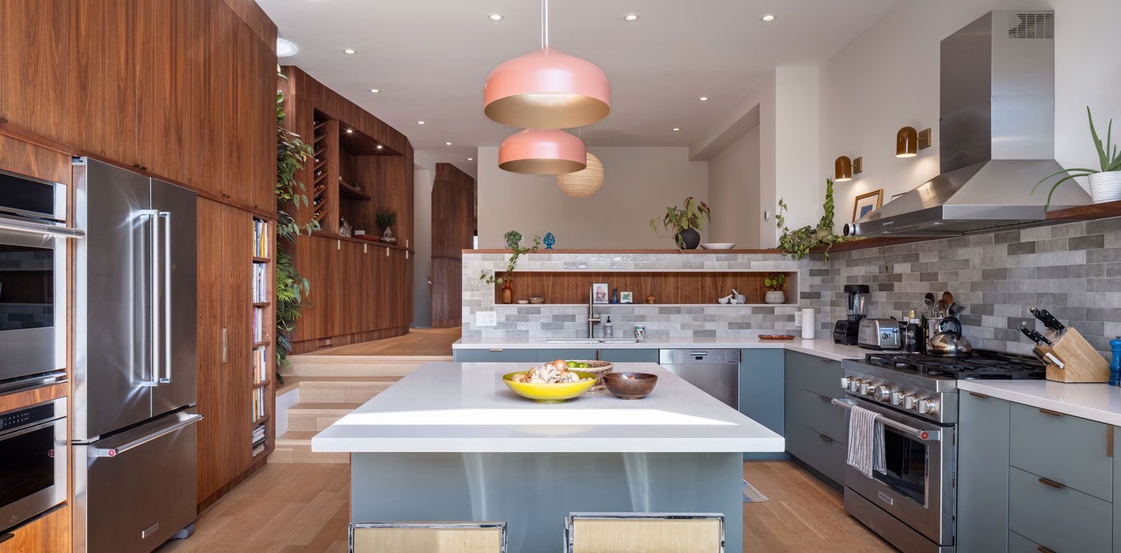 A kitchen with stainless steel appliances and a large island in the middle.