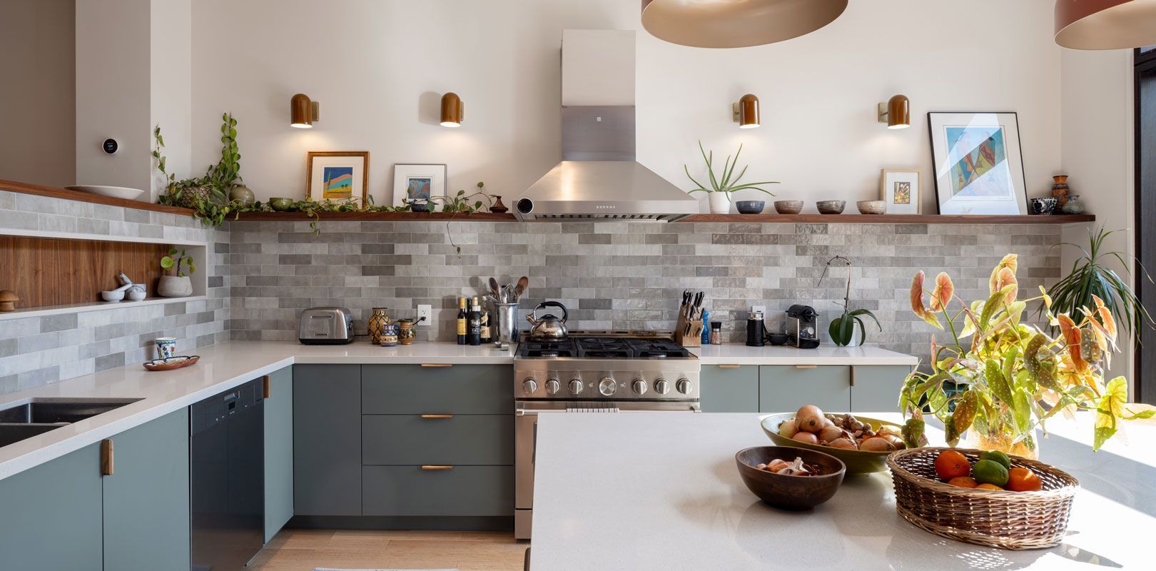 A kitchen with blue cabinets , white counter tops , a stove , a sink , and a large island.