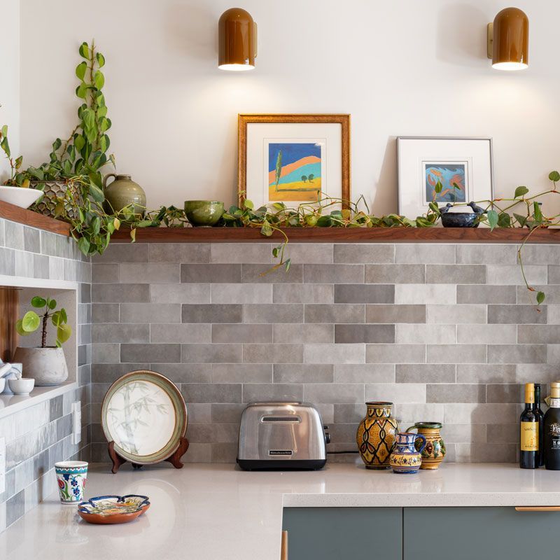 A kitchen with a toaster and a clock on the counter