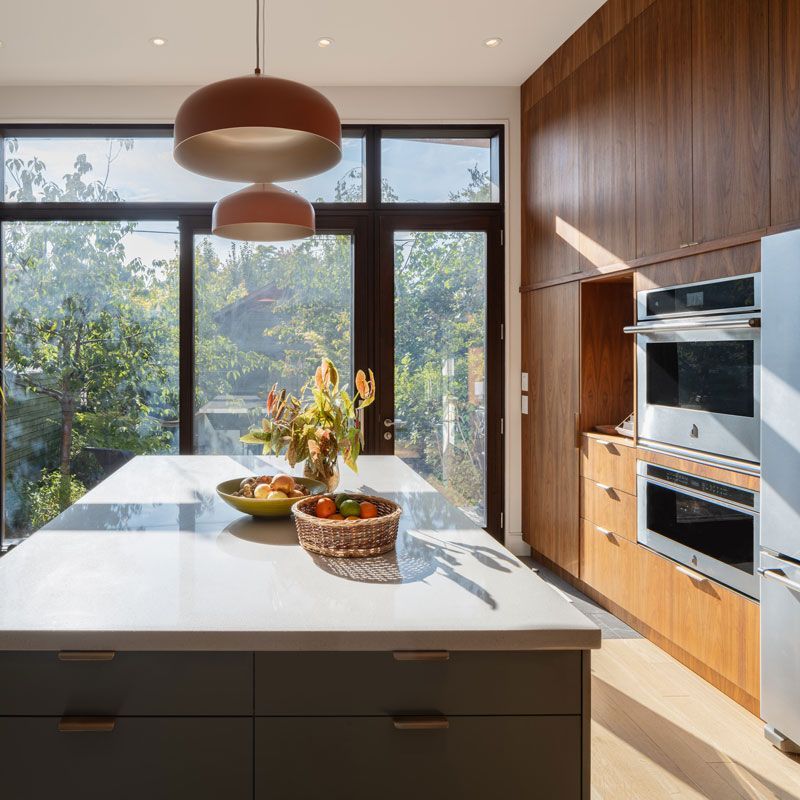 A kitchen with a large island and a bowl of fruit on it