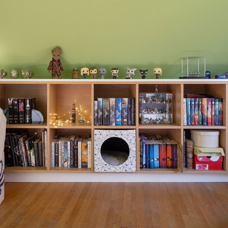A bookshelf with lots of books and toys on it