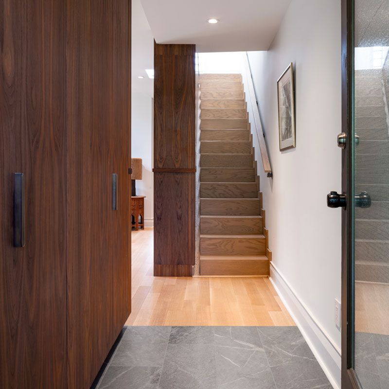 A hallway with stairs leading up to the second floor