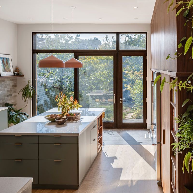 A kitchen with a large island and a large window